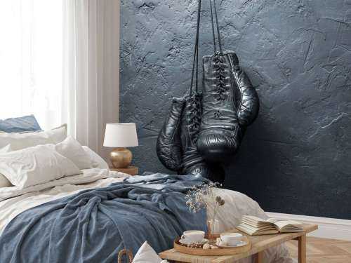 Old school zwarte bokshandschoenen aan een donkere muur