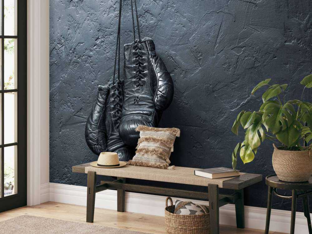 Old school zwarte bokshandschoenen aan een donkere muur